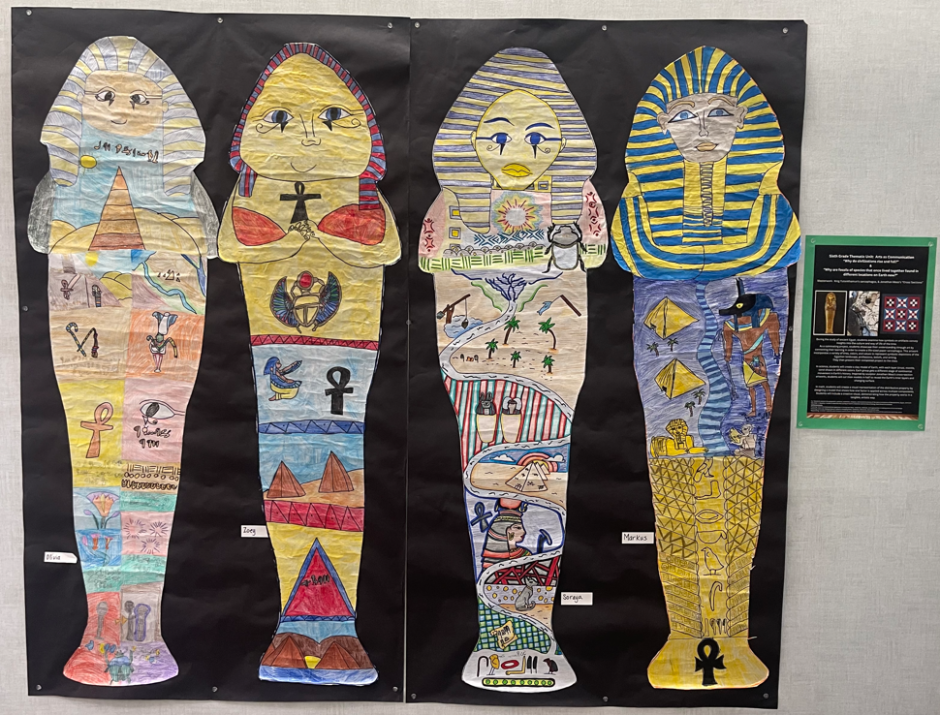 Life-size paper sarcophagus artwork with colorful drawings and shapes