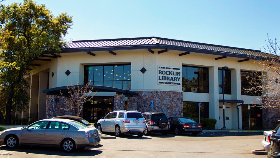 White and dark brick facade of the Rocklin Library in Rocklin, CA with cars parked outside